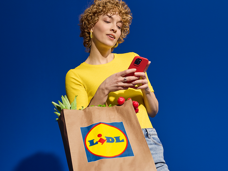 Kvinna med Lidl-kasse och mobil